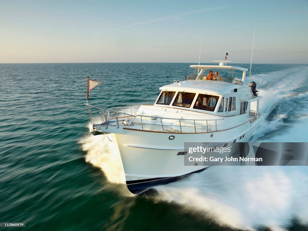 Couple on yacht powering through sea