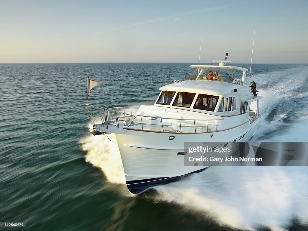 Couple on yacht powering through sea