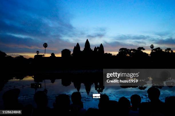 a lot of tourists take photos of dawn of angkor wat - 遺跡 stock-fotos und bilder