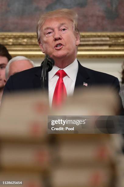 President Donald Trump speaks behind a table full of McDonald's hamburgers, Chick fil-a sandwiches and other fast food as he welcomes the 2018...