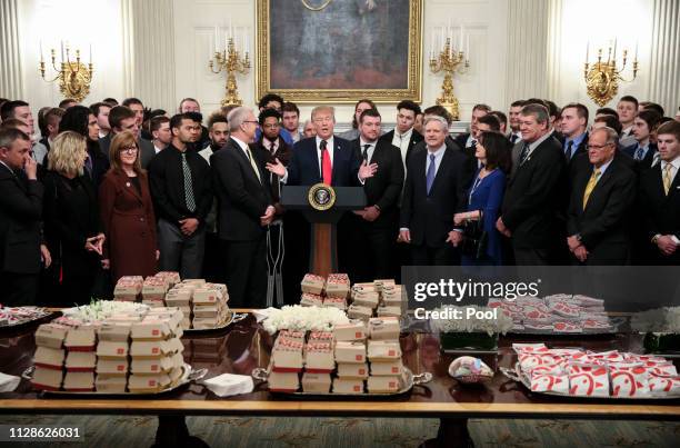 President Donald Trump speaks behind a table full of McDonald's hamburgers, Chick fil-a sandwiches and other fast food as he welcomes the 2018...