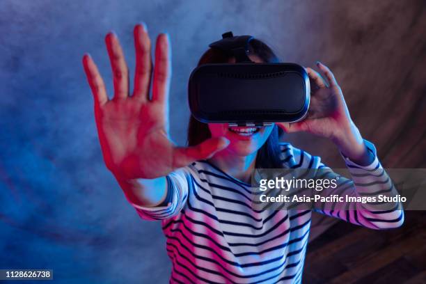 attractive asian girl with vr goggles on head - flying goggles imagens e fotografias de stock