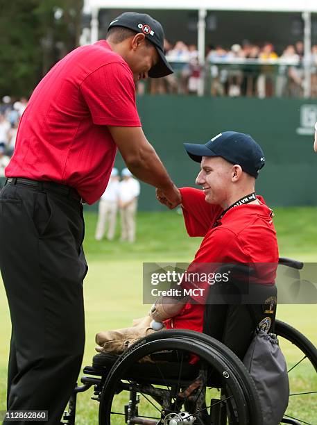 Tiger Woods greets PFC Brendan Marrocco who was injured in Tikrit, Iraq, after Woods won the AT&T National, at Congressional Country Club in...