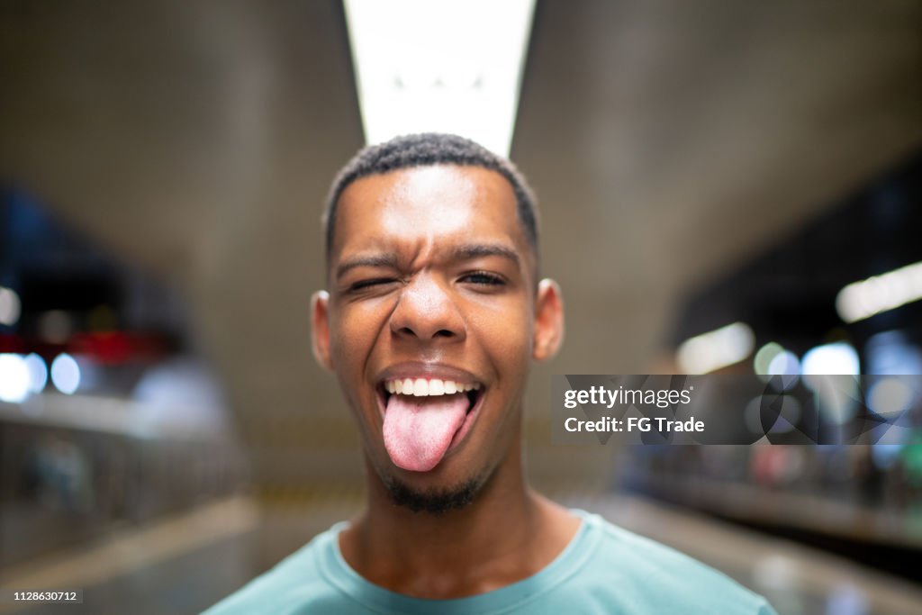 Afro latinx young man making a face at the metro portrait