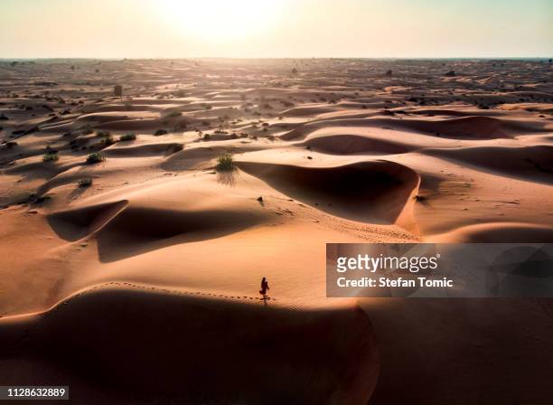 woman walking in the desert aerial view - dubai sunset desert stock pictures, royalty-free photos & images