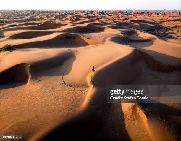 donna che cammina nella vista aerea del deserto - dune foto e immagini stock
