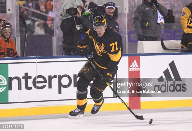 Evgeni Malkin of the Pittsburgh Penguins skates the puck along the right wing boards during the 2019 Coors Light NHL Stadium Series game between the...