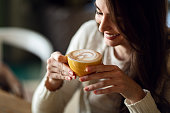 Happy woman enjoying in cup of fresh coffee.