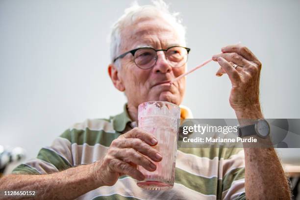 a senior man with a cold drink - man drinking milkshake stock pictures, royalty-free photos & images