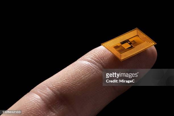 small rfid nfc labels on tip of finger - rfid technology stock pictures, royalty-free photos & images