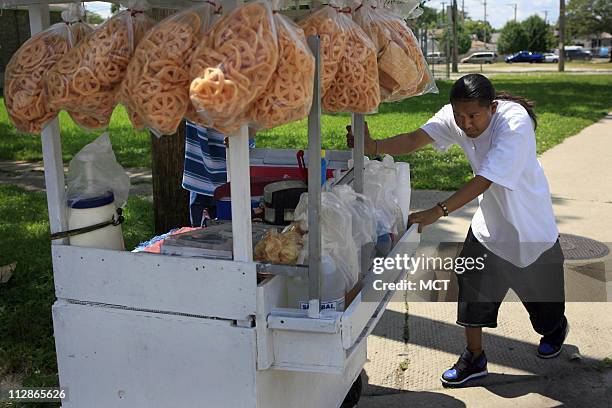 Omar Castillo pushes a food cart through the Gage Park neighborhood in Chicago, Illinois, July 31, 2009. Castillo, a kidney transplant recipient and...