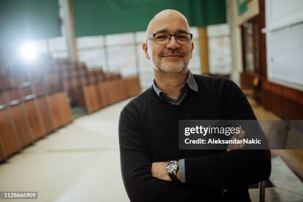 porträt von lächelnden professor im amphitheater - college teacher stock-fotos und bilder