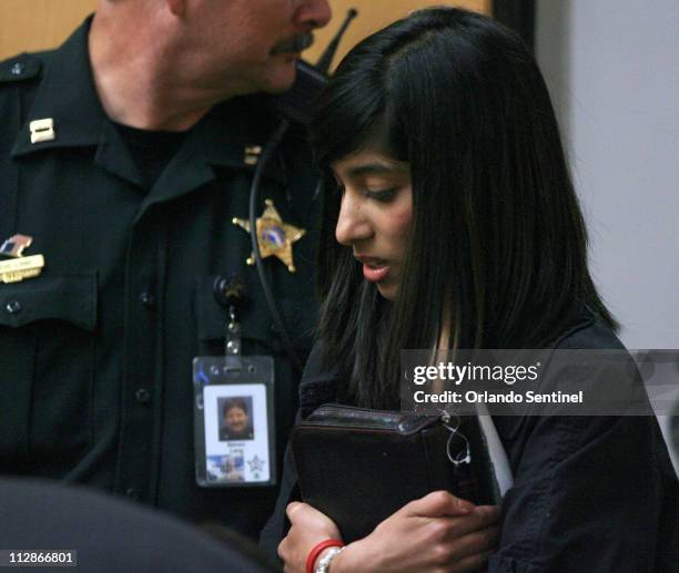 Fathima Rifqa Bary enters the courtroom of Circuit Judge Daniel Dawson, on Friday, August 21 hugging her Bible. Bary ran away from her Muslim family...