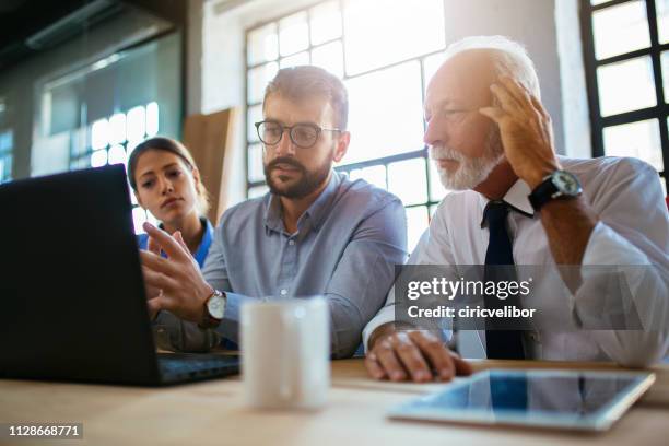 three business people having a meeting at the modern office - business meeting three people stock pictures, royalty-free photos & images