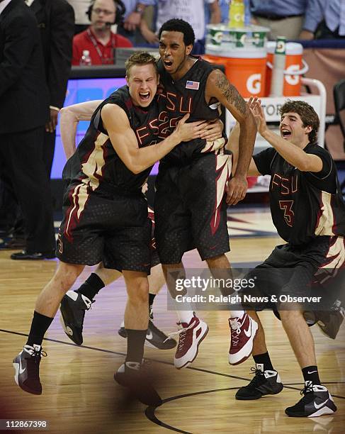 Florida State guard Deividas Dulkys , Derwin Kitchen and Luke Loucks celebrate at midcourt after upsetting North Carolina 73-70, during the ACC men's...