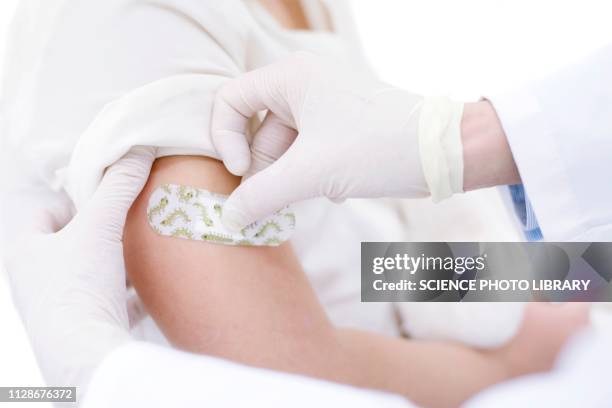 doctor sticking plaster on girl's arm after injection - applying plaster stock pictures, royalty-free photos & images