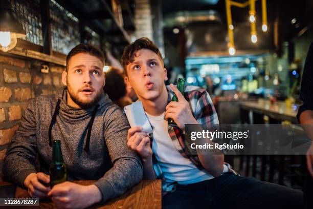 mannen die tv kijken - man in bar stockfoto's en -beelden