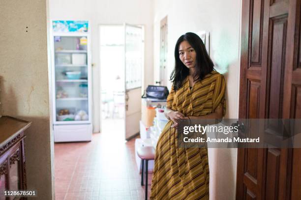 portrait of akha/thai woman at home in yellow dress - südostasiatischer abstammung stock-fotos und bilder