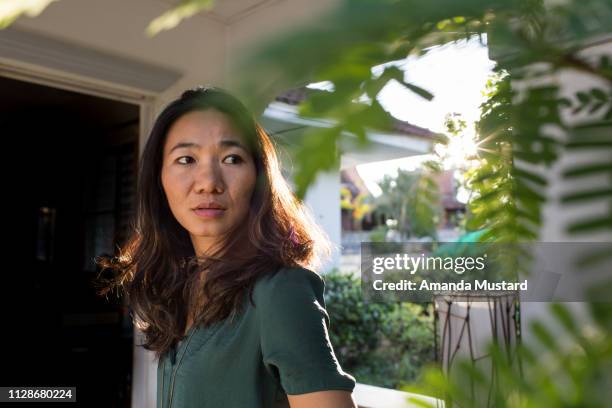 concerned akha/thai woman outside home in sunlight - akha woman stock pictures, royalty-free photos & images