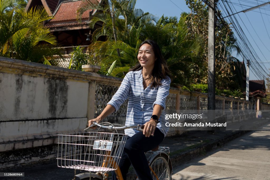 Happy Thai Woman Riding Bicycle with Basket