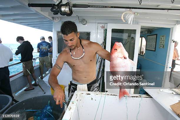 Paul Julian 2nd mate on the Deep Sea Fishing Boat "Sea Spirit" holds a Red Snapper fish that a patron caught in the Atlantic Ocean, March 19, 2009 on...
