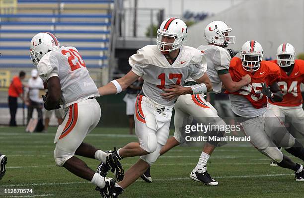 Miami's Taylor Cook passes the ball off to Damien Berry during the Hurricanes football spring scrimmage game at Lockhart Stadium in Fort Lauderdale,...