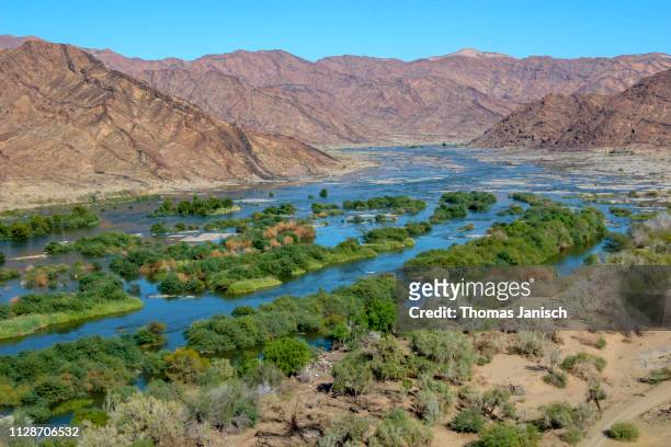 panoramic view overlooking a bend of the orange river, namibia - oranje stock-fotos und bilder