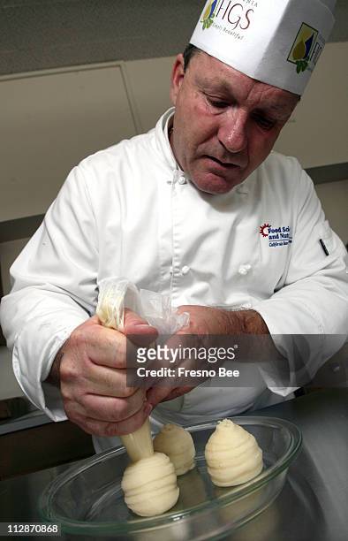 Fresno State professor Klaus Tenbergen squeezes out mashed potatoes as he prepares Duchess potatoes in Fresno, California, Wednesday, October 1, 2008.