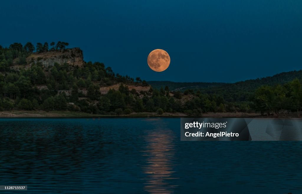 Lake with full moon in spanish mountains