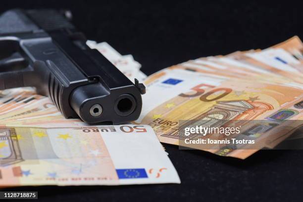 ull frame shot of fifty euro banknotes and a gun - gangster foto e immagini stock