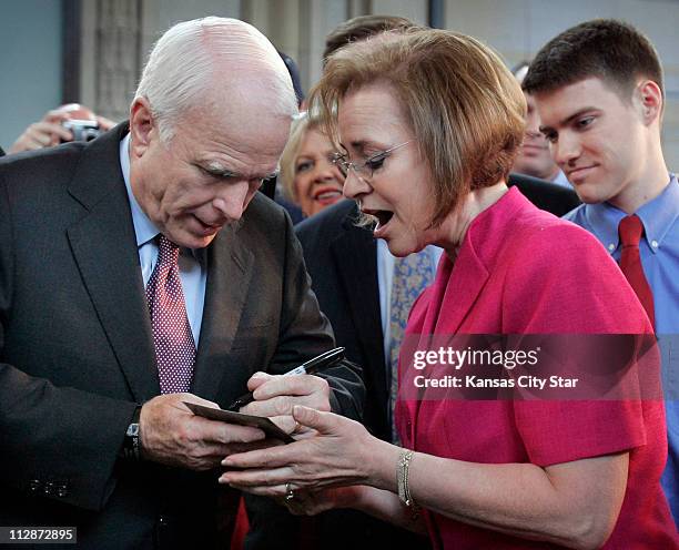 Republican presidential candidate Sen. John McCain signed a card for health savings account advocate Beverly Gossage of Eudora, Kan., following a...