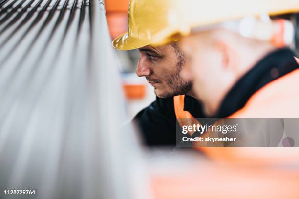 manual workers cooperating while working with metal in aluminum mill. - distribution warehouse stock pictures, royalty-free photos & images