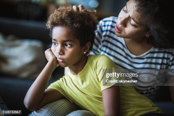 african american mother consoling her small daughter at home. - stupid girls stock pictures, royalty-free photos & images