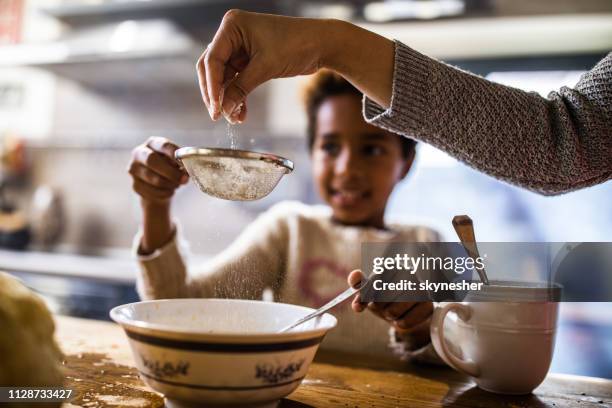 sieben mehl in der küche! - black mother and child cooking stock-fotos und bilder