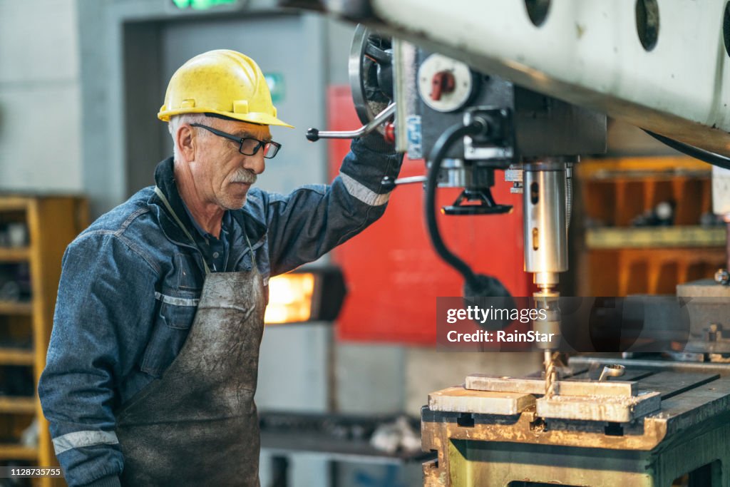 Turner worker working on drill bit in a workshop
