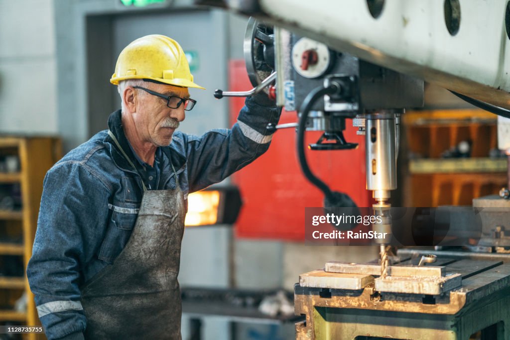 Turner arbetstagaren arbetar på borr i en workshop