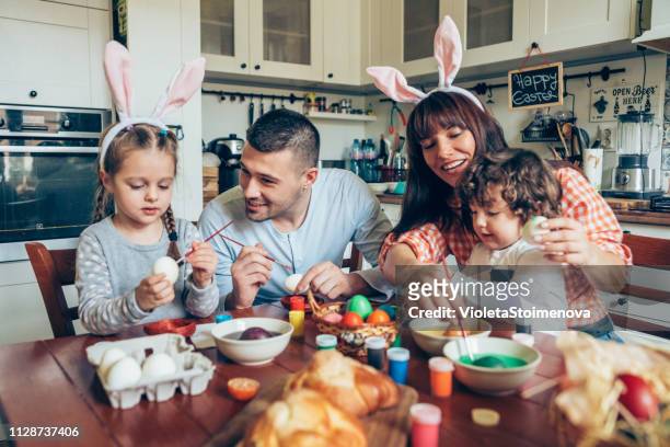 happy family painting easter eggs - easter egg stock pictures, royalty-free photos & images