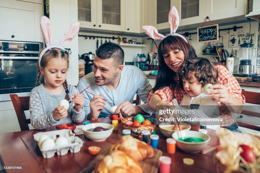 Happy family painting Easter eggs