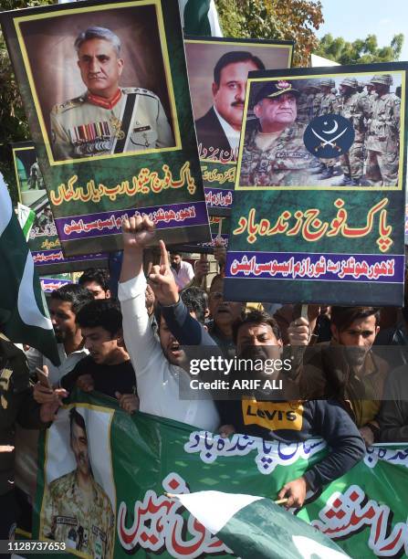 Pakistani traders shout slogans and carry posters with the image of Pakistani Army Chief General Qamar Javed Bajwa during an anti-India protest, in...