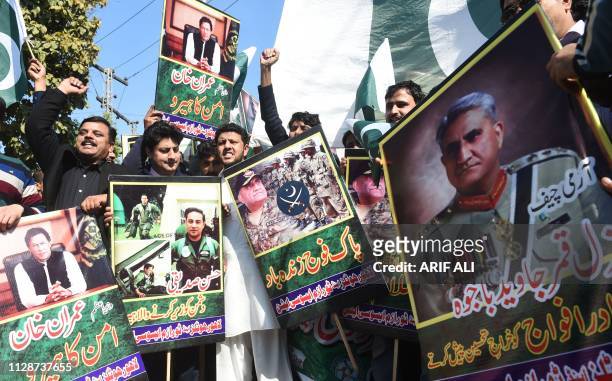 Pakistani traders shout slogans and carry posters with the image of Pakistani Army Chief General Qamar Javed Bajwa during an anti-India protest, in...