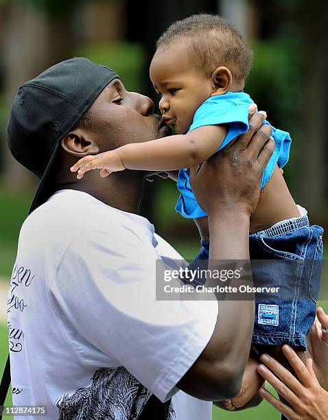Carolina Panthers linebacker Thomas Davis kisses his eight-months-old son, Thomas Davis Jr., goodbye as he prepares to head to the team's dormitory...
