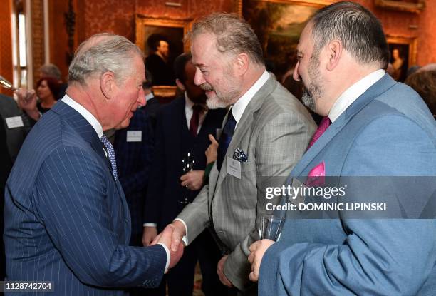 Britain's Prince Charles, Prince of Wales talks with Welsh actor Owen Teale and Welsh singer Wynne Evans during a reception to mark the 50th...