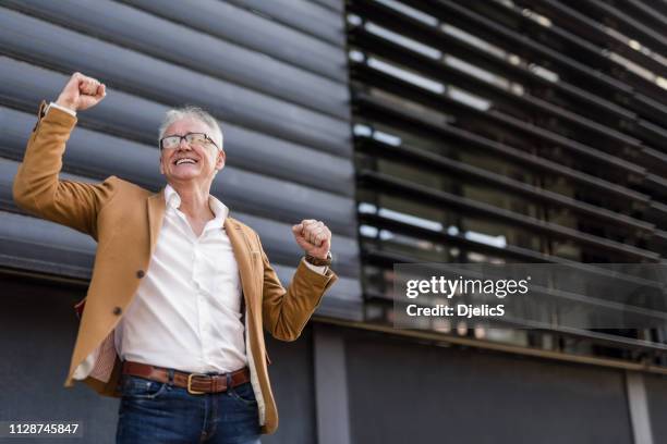 extatisch rijpe zakenman vieren succes. - werkende bejaarden stockfoto's en -beelden