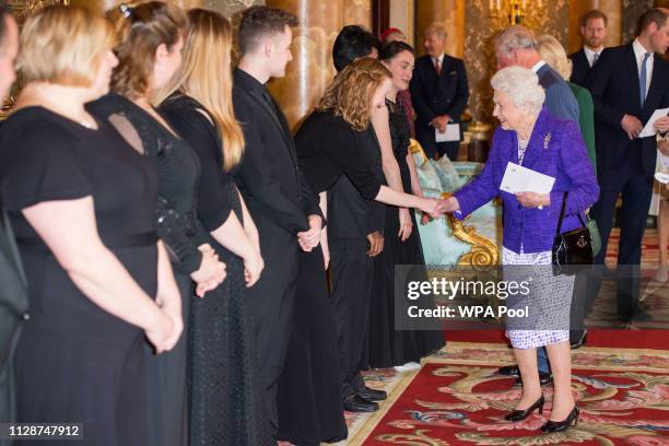 Queen Elizabeth II meets perfromers as she attends a reception to mark the fiftieth anniversary of the investiture of the Prince of Wales at...