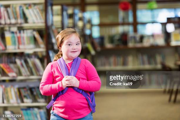 School girl with down syndrome in library