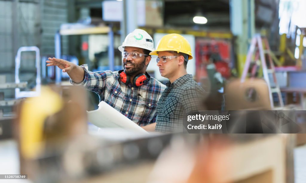 Multi-ethnic workers talking in metal fabrication plant
