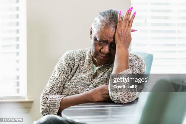 senior afro-amerikaanse vrouw met hoofdpijn, boos - negatieve eigenwaarde stockfoto's en -beelden
