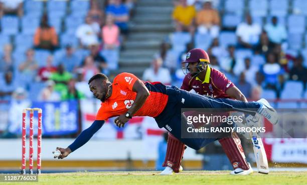 Chris Jordan of England takes the catch to dismiss Darren Bravo of the West Indies as Nicholas Pooran looks on during a T20 match between the West...