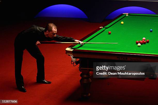Graeme Dott of Scotland plays a shot in the round two game against Ali Carter of England on day seven of the Betfred.com World Snooker Championship...
