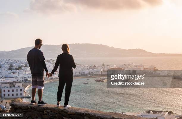 traveler couple looking at a view in mykonos - mill house stock pictures, royalty-free photos & images